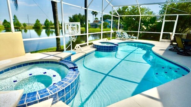 A swimming pool with a hot tub and a basketball hoop, surrounded by a covered area with chairs. - Ref 417.  Stunning villa in perfect location Close to Disney (Four Corners)