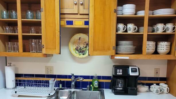 Eine Küche mit Holzausstattung, einem Spülbecken und einer Kaffeemaschine.