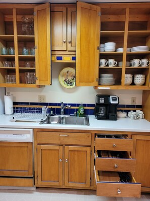 A kitchen with wooden cabinets, a sink, and a coffee maker. - Home in State College (State College)