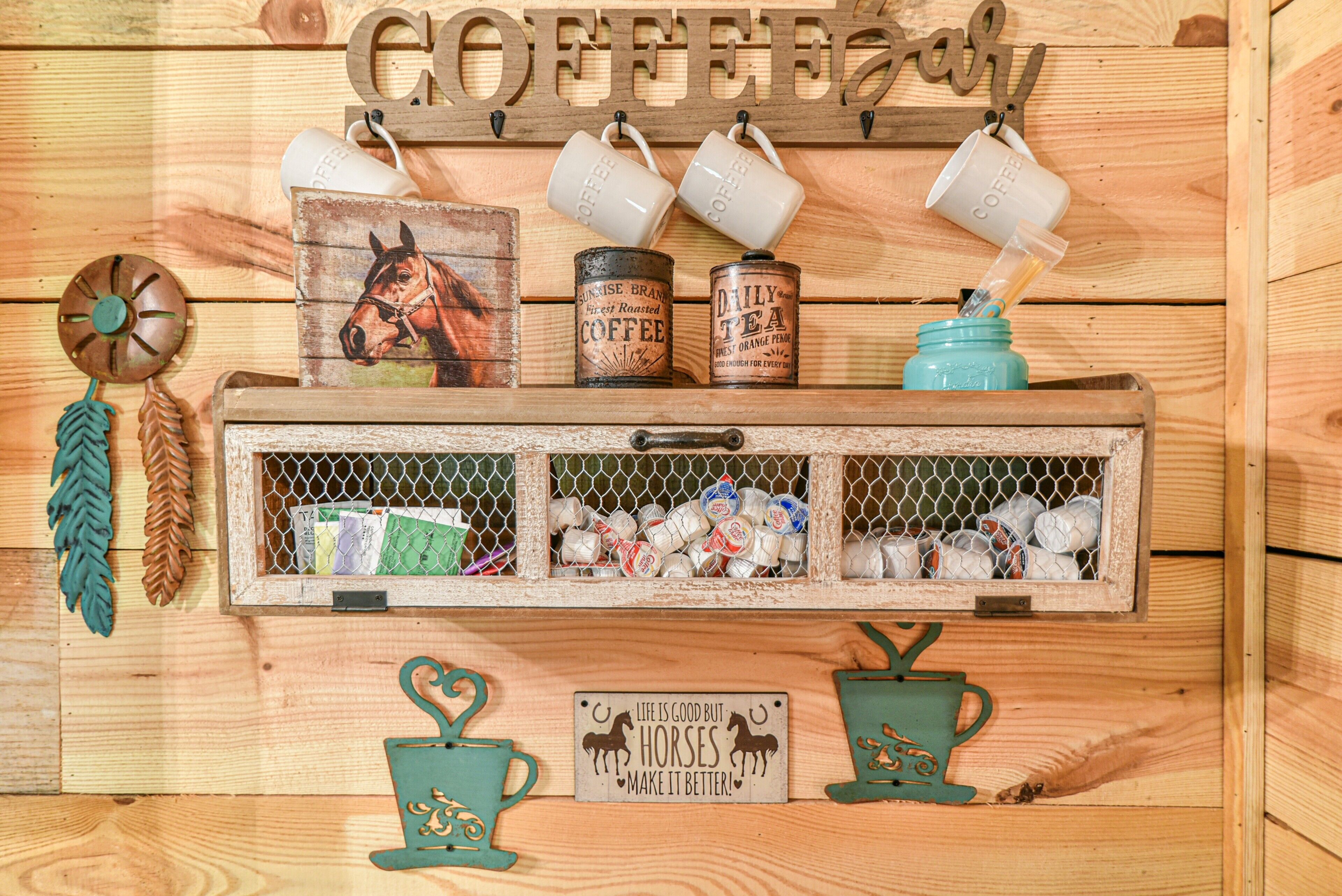 A wooden shelf with coffee mugs, a horse painting, and a sign saying 'Life is good but horses make it better.'