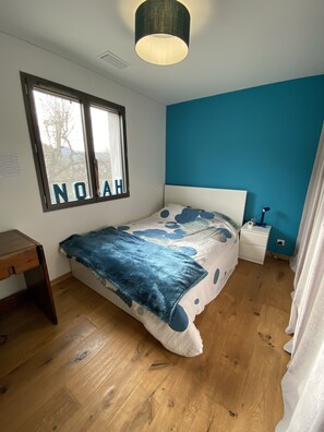 Relax in this serene bedroom with a comfortable bed, desk, and stunning mountain views.