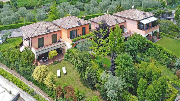 A residential property with a patio, a covered outdoor seating area, and a well-maintained garden. - Casa Monte Cicogna PT 1 by Wonderful Italy (Moniga del Garda)