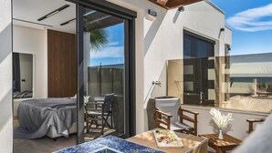 Un espacio exterior moderno con una mesa de comedor, sillas y un jarrón decorativo.