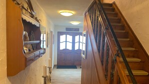A wooden staircase leading to a door with a frosted glass window. - Alpine Holiday Home in Lungau (Vordermuhr)