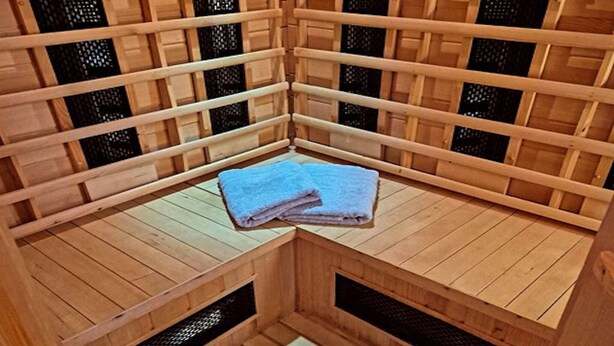 A sauna room with wooden benches and a bench with towels. - Alpine Holiday Home in Lungau (Vordermuhr)