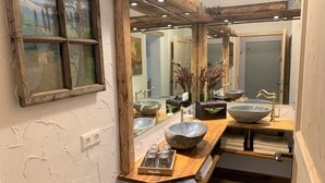 A bathroom with a rustic design, featuring a wooden vanity, large stone sinks, and a mirror with a wooden frame. - Alpine Holiday Home in Lungau (Vordermuhr)