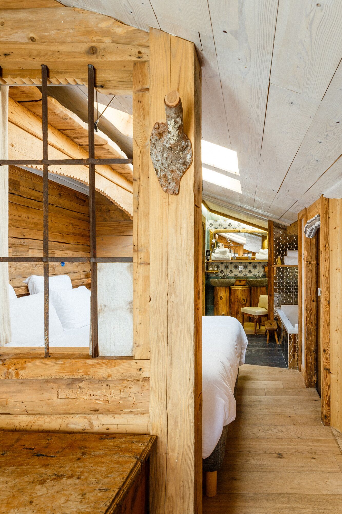 Une cabane en bois avec des lits superposés, un petit coin cuisine et un escalier.