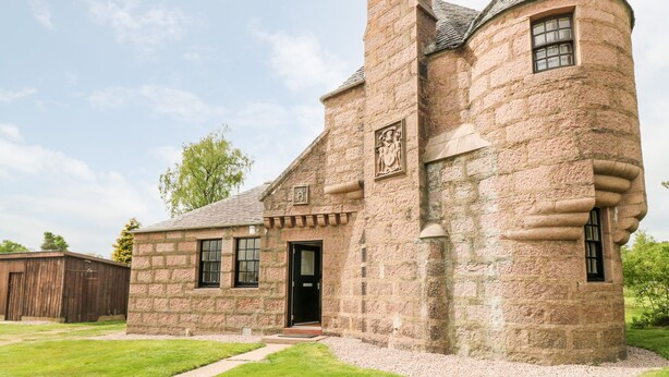 A stone building with a turret and a chimney, featuring a door and windows. - Holly Leaf Cottage - Drum Castle Estate (Banchory)