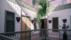 A multi-level interior with a staircase, wrought iron railings, and potted plants. - Riad Lalla Mimouna (Marrakech)