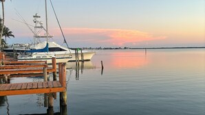 A marina with docked boats, calm water, and a clear sky.