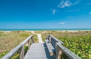 A wooden boardwalk leading to a beach with a clear view of the ocean. - Corner unit private balcony ocean view, pool & spa, beachfront access in Florida (Cape Canaveral)
