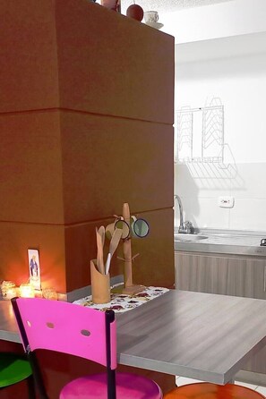 A kitchen with a wooden cabinet, a table with a placemat, and a chair.