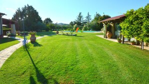 A well-maintained lawn with a pathway, a bicycle, and a gazebo.