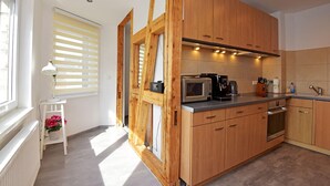 A modern kitchen with wooden cabinets, a microwave, and a coffee maker. - Rückzugsort mit Waldblick (Zella-Mehlis)