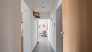 A hallway with a wooden door, a telephone, and a small table with a chair. - Rückzugsort mit Waldblick (Zella-Mehlis)