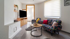 A living room with a sofa, coffee table, TV, and a wooden cabinet. - Rückzugsort mit Waldblick (Zella-Mehlis)