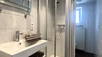 Chuveiro, secador de cabelo, toalhas de banho, sabonete