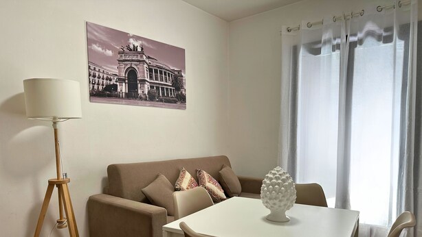 Una sala de estar con un sofá, una mesa de comedor y una lámpara.