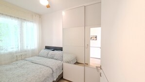 A bedroom with a bed, a wardrobe, and a window with curtains. - Casa Irene le Balze apartment lake view (Tremosine)