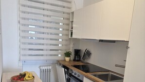 A compact kitchen with a wooden countertop, a built-in oven, a sink, and a window with blinds. - Casa Irene le Balze apartment lake view (Tremosine)