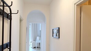 A hallway with a ceiling light, a bench, a door, and a framed picture on the wall. - Casa Irene le Balze apartment lake view (Tremosine)