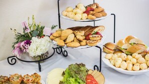 A three-tiered dessert stand with various pastries and sandwiches. - Fono Hôtel (Yaoundé)