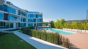A modern multi-story building with a swimming pool, surrounded by well-maintained grass and plants. - Bristol Exclusive 2 5 by Wonderful Italy (Lonato del Garda)