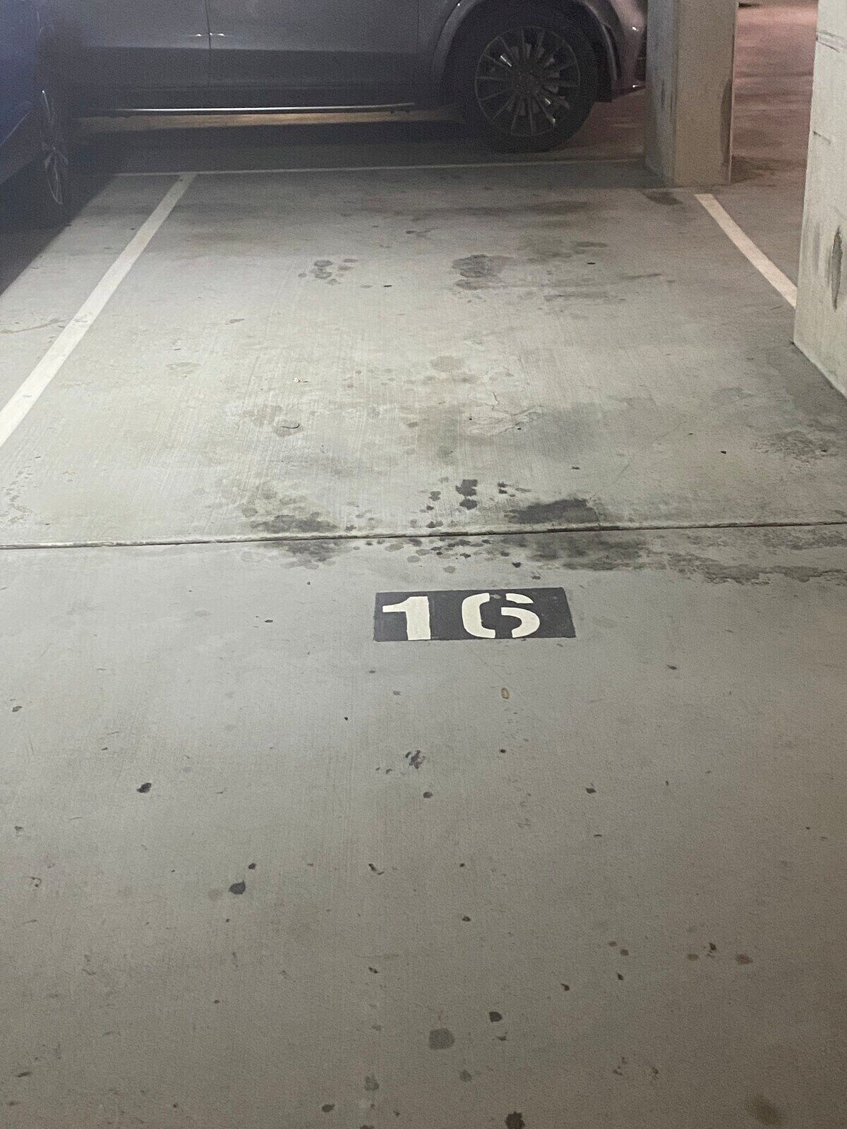 A parking garage with a concrete floor and a white line marking.