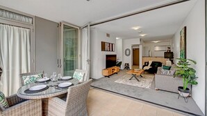 En moderne lejlighed med spiseplads, opholdsstue og balkon.