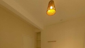 A hotel room with two beds, a wardrobe, a shelf, and a hanging light fixture. - Residencial Terrazas (Florianópolis)