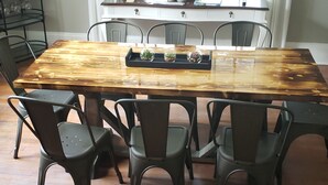 Une table de salle à manger rectangulaire, dotée d’un plateau en bois, entourée de six chaises noires.