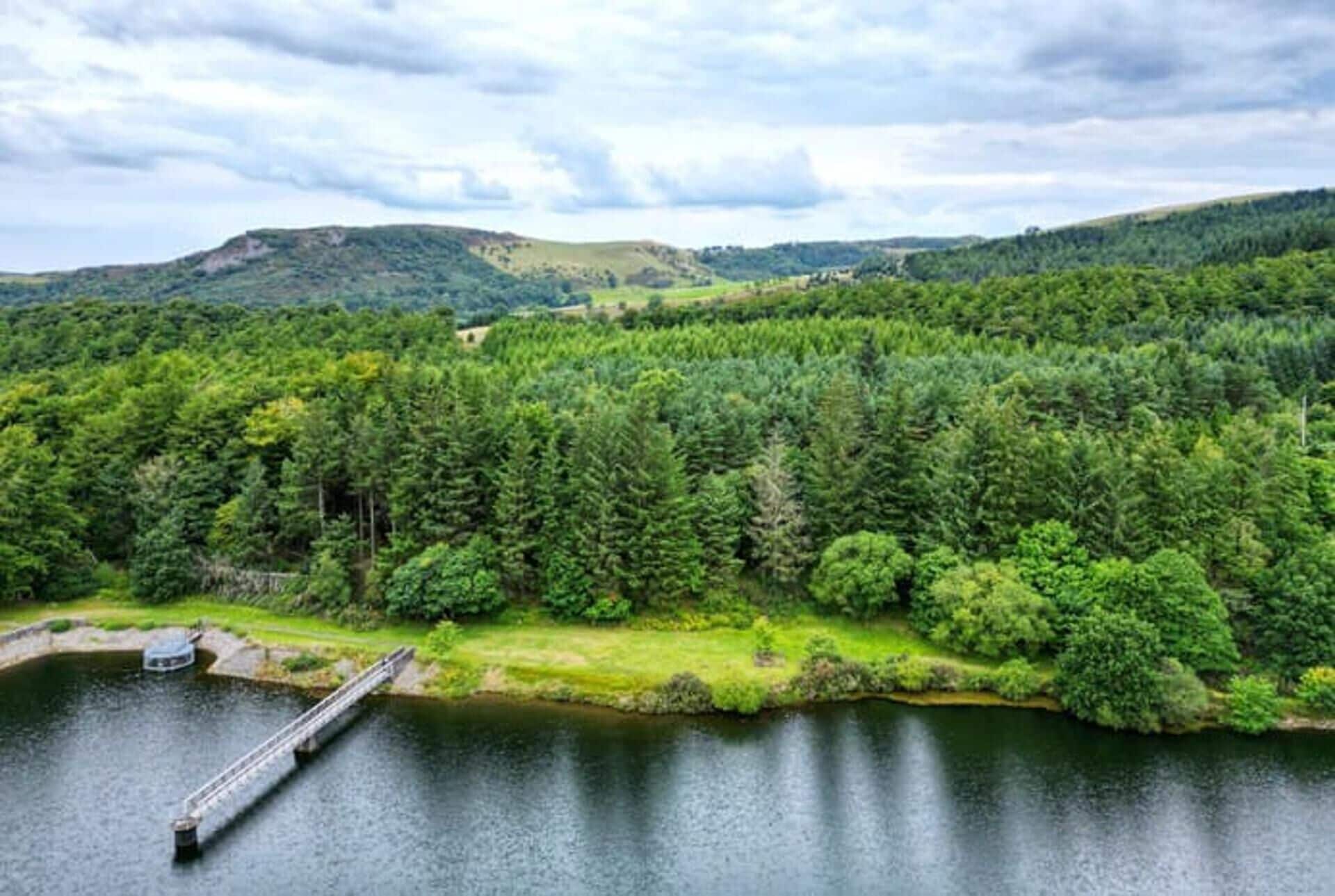 A lake surrounded by dense forest and hills.