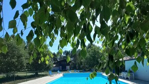 A rectangular swimming pool with clear blue water, surrounded by a tiled deck.