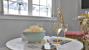 A round table with a bowl of popcorn, two glasses of white wine, and a board game. - Charming, quiet, sun filled, lakefront  (Willis)
