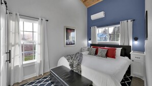 A bedroom with a bed, a bench, a window, and a ceiling fan. - Charming, quiet, sun filled, lakefront  (Willis)
