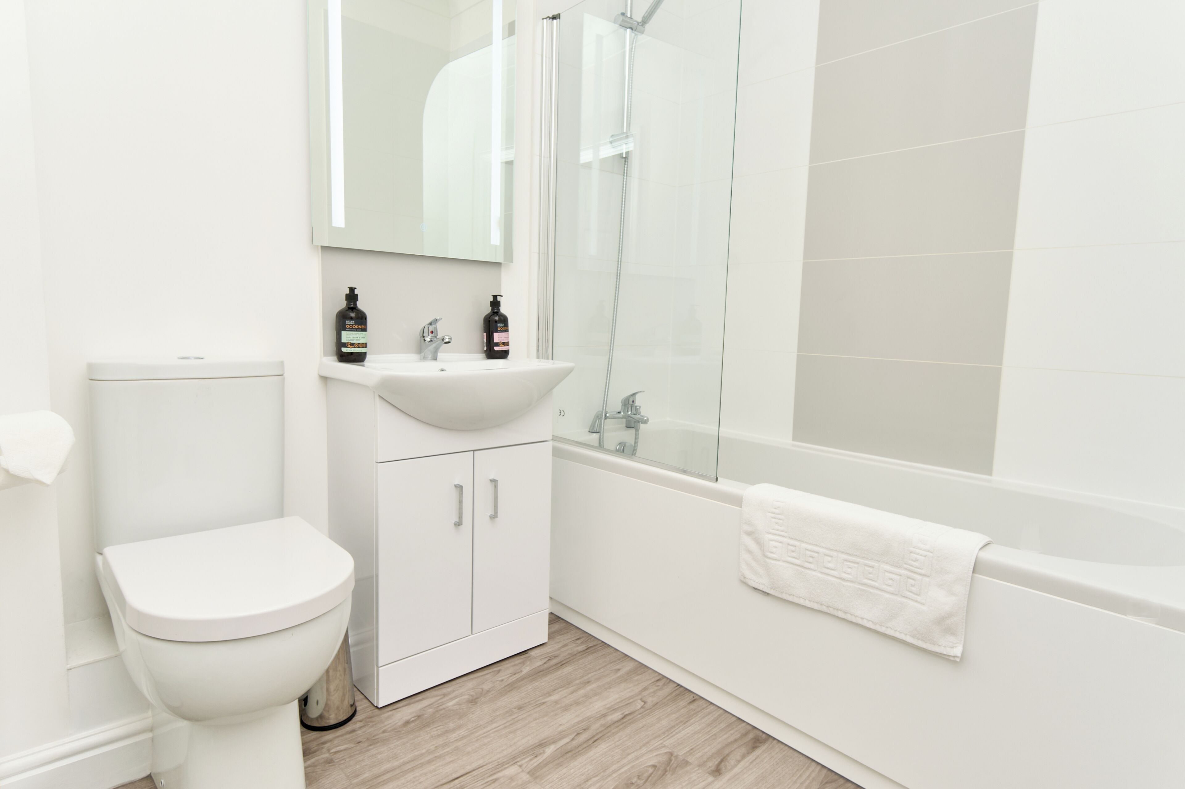 A modern bathroom with a toilet, sink, and shower.