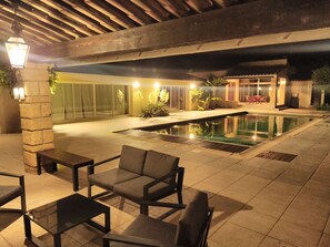 An outdoor pool area with seating and a covered patio. - Domaine Privé Le Moulin Neuf Uzés 40 people 2 swimming pools Enclosed park. tennis court (Sainte-Anastasie)