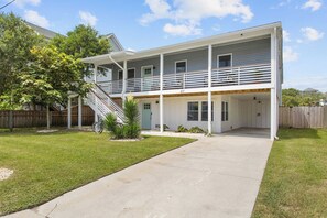 A two-story house with a covered patio and a staircase leading to the upper level. - WALK TO THE BEACH!!! Entire 5 bedroom home + game room & fenced in grilling area (Carolina Beach)