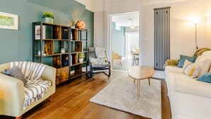 A modern living room with a sofa, a coffee table, and a bookshelf.