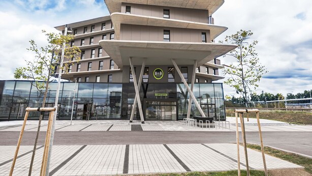 Un hôtel moderne doté d’une architecture originale, avec plusieurs niveaux et une entrée imposante.