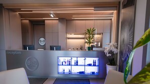 Un espace d’accueil comprenant un comptoir de réception, un bar et des sièges.