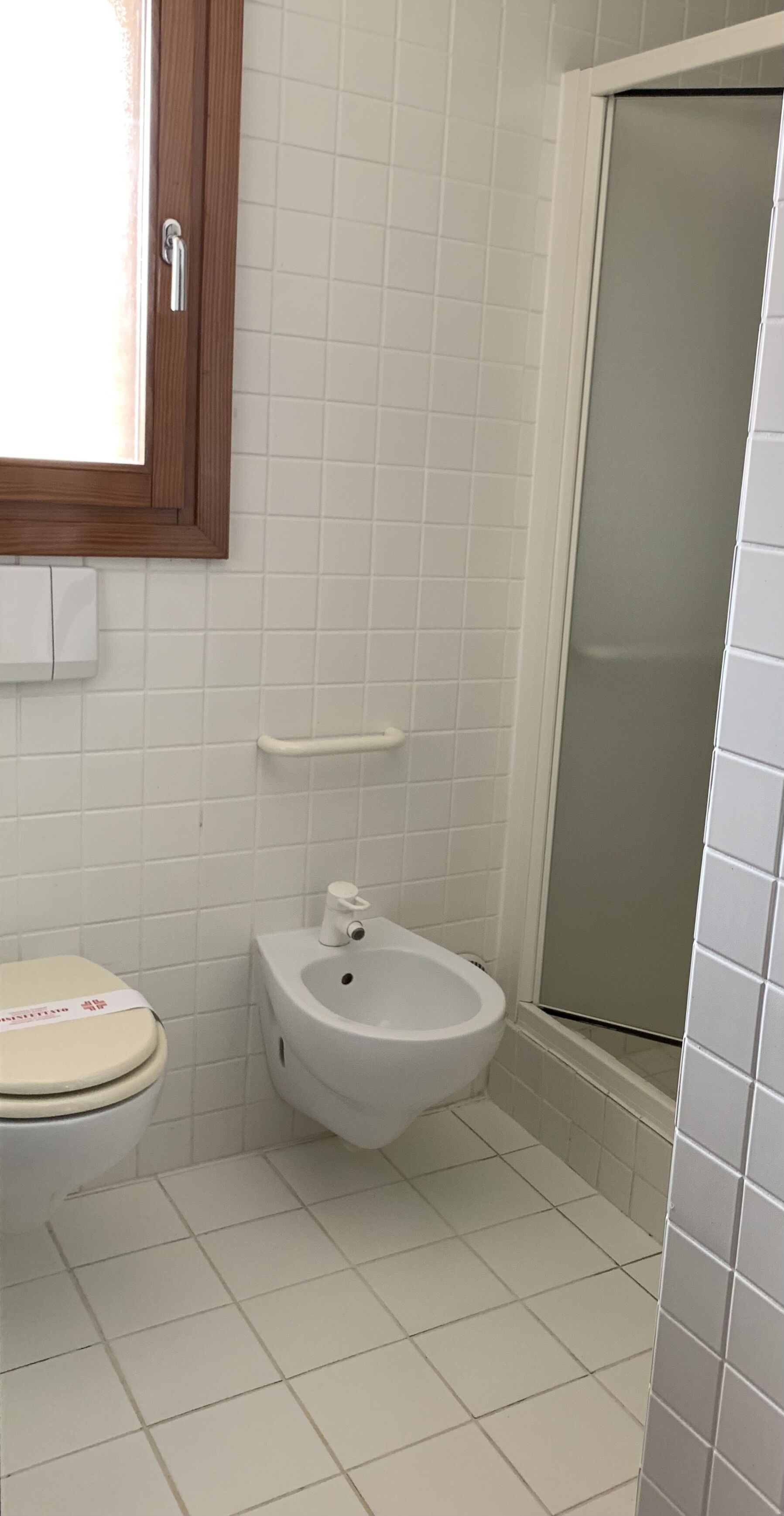 Ein Badezimmer mit Toilette, Bidet und Duschkabine.