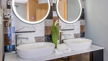 Un bagno moderno con due lavabi, uno specchio grande e un pannello decorativo in piastrelle.
