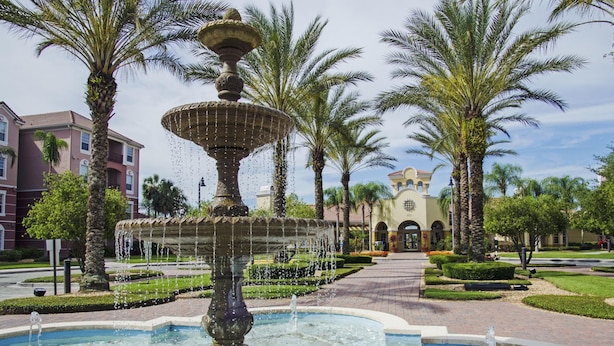 A fountain with multiple tiers and water jets, surrounded by palm trees and a well-maintained garden. - Vista Cay Luxury Lakeview 3 Bedroom Condo 3087 (Orlando)