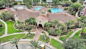 A resort with multiple swimming pools, a central building with a bell tower, and a well-maintained garden area. - Vista Cay Luxury Lakeview 3 Bedroom Condo 3087 (Orlando)