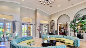 A spacious lobby with a curved seating area, large windows, and a visible exit sign. - Vista Cay Luxury Lakeview 3 Bedroom Condo 3087 (Orlando)