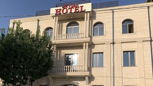 A hotel with a symmetrical facade, large windows, and a central entrance with a glass door. - Nur Makon (Tashkent)