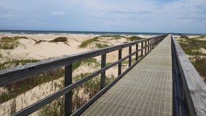 A wooden boardwalk leading to a beach with sand dunes and the ocean in the background. - Oceanview, Updated, Wi-Fi , Pool.  Family Unit for 6 -  Must be 25+ to rent. (Matagorda)