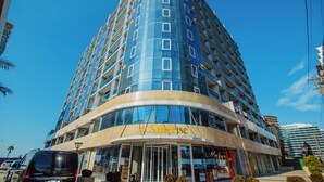 A modern hotel with a curved facade, multiple balconies, and a prominent entrance. - Lovely Studio in Batumi With Rooftop in Building (Batumi)