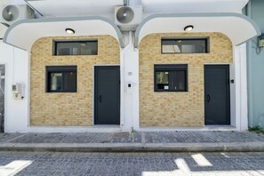 A building with two identical doors, each with a small window above. - Loft 1 (Kos)